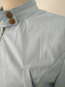 Dettaglio giacca in pelle scamosciata azzurra con colletto alla coreana e zip
