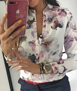 Dettaglio della camicia bianca a maniche lunghe con stampa floreale e bottoni dorati