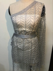 Détail de la maille métallique argentée et bretelle asymétrique de la robe moulante