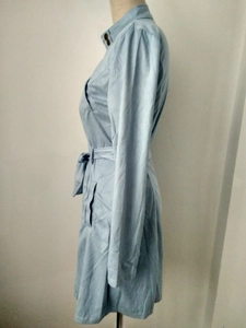 Dettaglio del cappotto in pelle scamosciata azzurra con cintura e colletto su manichino