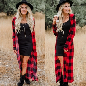 Fashionable red plaid long cardigan with black mini dress and boots in autumn nature