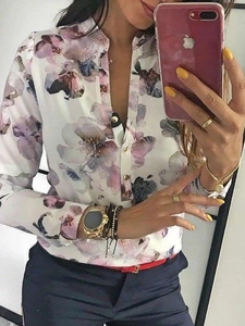 Dettaglio della camicia a fiori a maniche lunghe con scollo a V e chiusura a bottoni