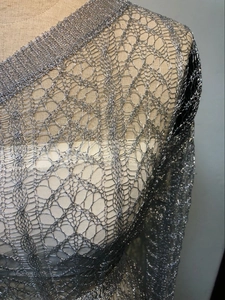 Détail du tissu en maille creuse métallique argentée avec texture fine et fini brillant