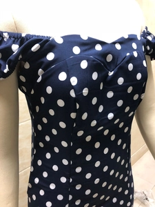 Détail du décolleté en cœur et des volants sur la robe à pois avec épaules dénudées