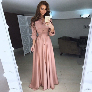 Détail d'une robe chemise rose poudré à manches longues avec ceinture et fermeture boutonnée