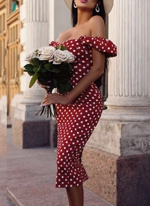 Détail d'une robe rouge à pois avec épaules dénudées et fente latérale de style vintage