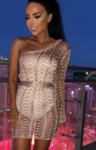 Détail macro de paillettes or rose avec motif fléché géométrique sur robe de soirée ajustée