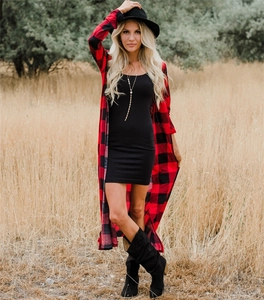 Outdoor shot of long red and black buffalo plaid cardigan with a black midi dress