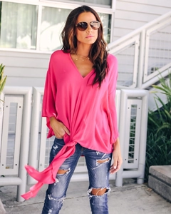 Detail of V-neck fuchsia chiffon top featuring a stylish front knot and airy flutter sleeves