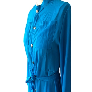 Détail du col montant et de la patte de boutonnage d'une robe chemisier bleue