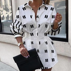 Détails des plis à la taille et imprimé noir sur robe chemise blanche à manches longues