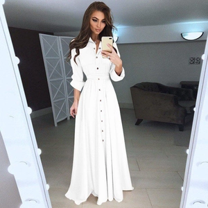 Gros plan détaillé d'une robe longue blanche boutonnée avec ceinture à la taille