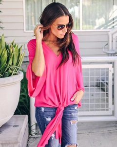 Detail of hot pink V-neck chiffon top with flutter sleeves and front knot detail