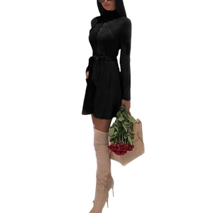 Giacca scamosciata nera da donna con cintura e stivali beige sopra il ginocchio