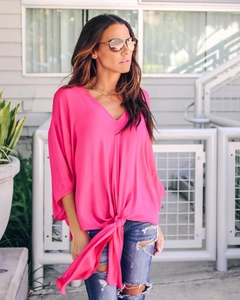 Detail of rose pink chiffon top with V-neckline and tie-front knot design at the waist