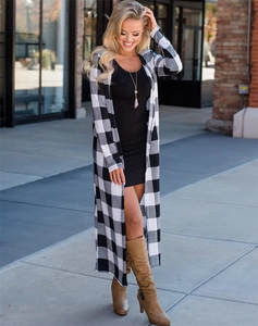 Detail shot of long black and white plaid cardigan paired with brown suede boots