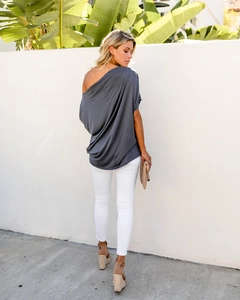Detail of loose dark grey off-shoulder top with asymmetric neckline and draped texture