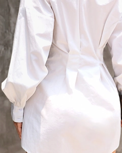 Vue détaillée du dos d'une robe chemise blanche avec taille plissée et manches lanternes