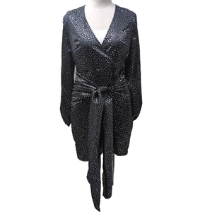 Détail de robe cache-cœur col en V noire à pois dorés et manches lanternes bouffantes