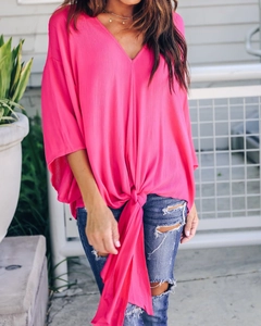 Detail of fuchsia V-neck chiffon top with a stylish central front knot design