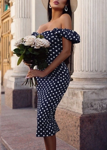 Détail d'une robe midi bleu marine à pois blancs avec encolure volantée aux épaules