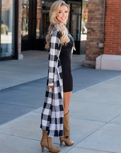 Detailed view of a long black and white plaid cardigan with city street style