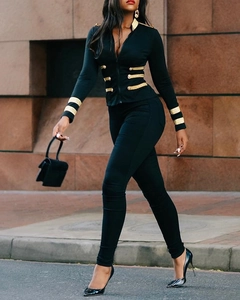 Detail of navy-style slim knit jacket with gold military buttons and striped cuffs