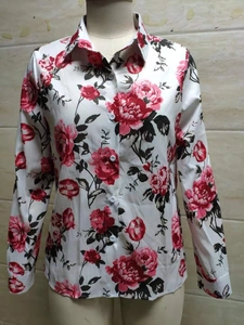 Détail de l'imprimé fleuri rose rouge sur une chemise blanche à manches longues