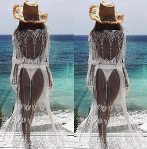 Detail of white lace beach cover-up with hollow floral patterns and elegant open-back design
