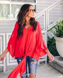 Detail of red V-neck chiffon blouse featuring ruffled sleeves and front tie knot design