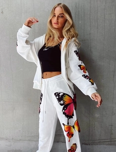 Detail of vibrant butterfly print on white hooded tracksuit sleeve and joggers