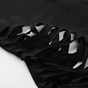 Macro detail of black cutout bandage design with ribbed knit texture and layered strap patterns