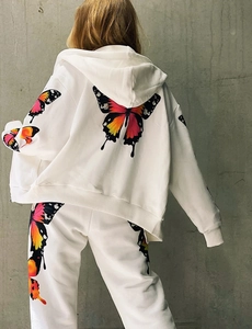 Detail of colorful butterfly print on white hoodie and jogger pants tracksuit set