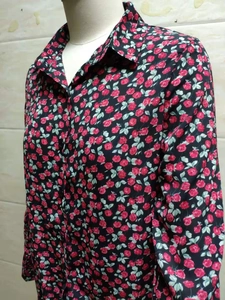 Détail de la chemise à manches longues avec imprimé floral de roses rouges sur fond noir