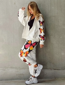 Detail of colorful butterfly prints on white zip-up hoodie and jogger pants set