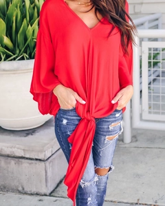 Detailed view of red V-neck chiffon blouse with front tie knot and flutter sleeves