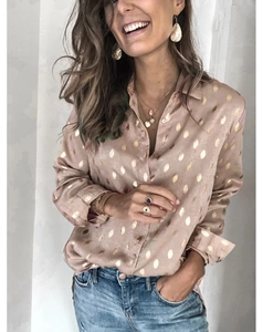 Détail d'une chemise en satin champagne avec pois dorés et un col au design élégant