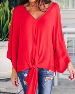 Close-up of bright red V-neck chiffon blouse with front knot and batwing sleeve detail