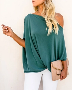 Detail of dark green off-shoulder top with batwing sleeves and twisted hem design