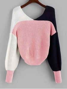 Close-up of color-block knit sweater featuring pink, white, and navy blue knit textures