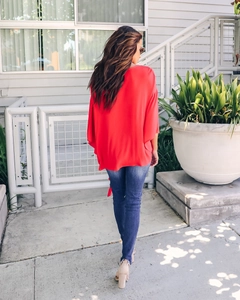 Rear view of loose red V-neck blouse with ruffle sleeves and stylish back tie detail