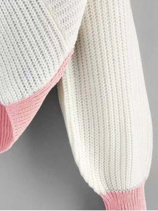 Close-up of knit texture with beige and pink color blocking on ribbed sweater cuff