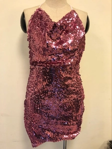 Detailed view of shimmering pink sequins and halter neck tie on a sequined mini dress