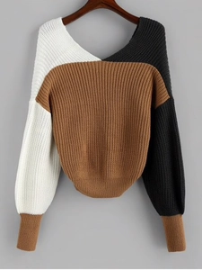 Detail of color-block knit sweater showing white, brown, and black ribbed texture