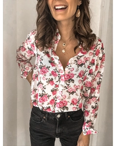 Détail d'un chemisier blanc à manches longues avec imprimé roses rouges et boutons