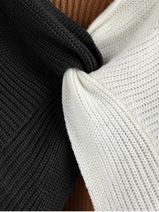 Close-up of twist detail on chunky knit sweater in black white and camel tones