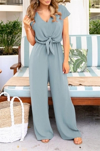 Macro shot of the waist tie and pleated texture on the light blue V-neck wide leg jumpsuit