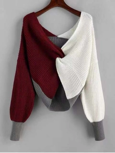 Detail of color-block knit sweater with criss-cross twist knot and wide V-neckline