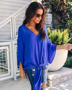 Detail of royal blue V-neck chiffon top featuring airy batwing sleeves and front tie knot