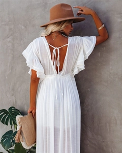 Detail of white V-neck bohemian maxi dress with backless tie design and ruffle sleeves